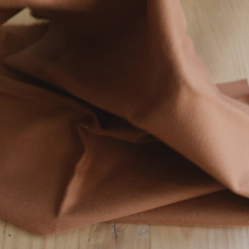 Hand crumples brushed cotton in an umber colour.