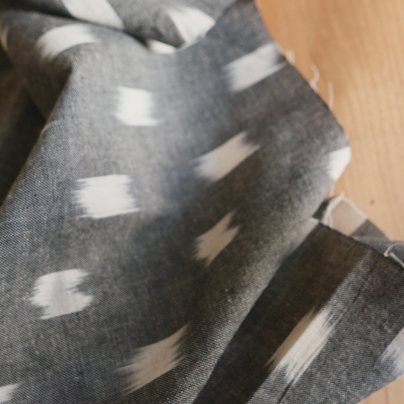 Grey fabric woven with a white woven square.