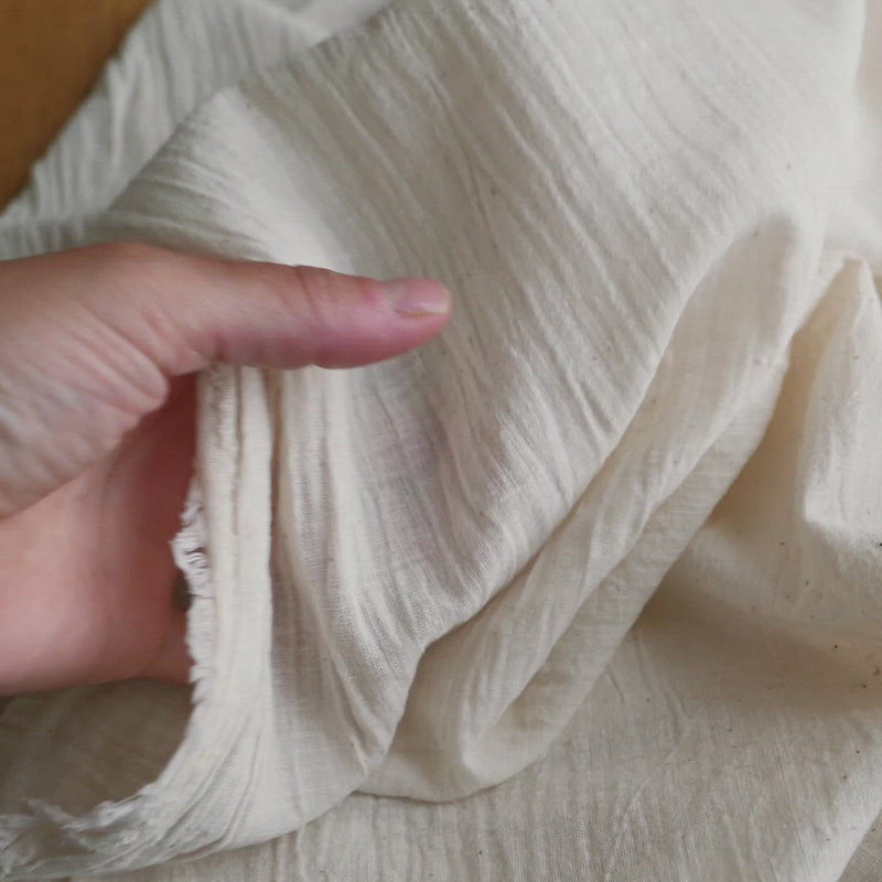 Cream fabric with a slubby texture.