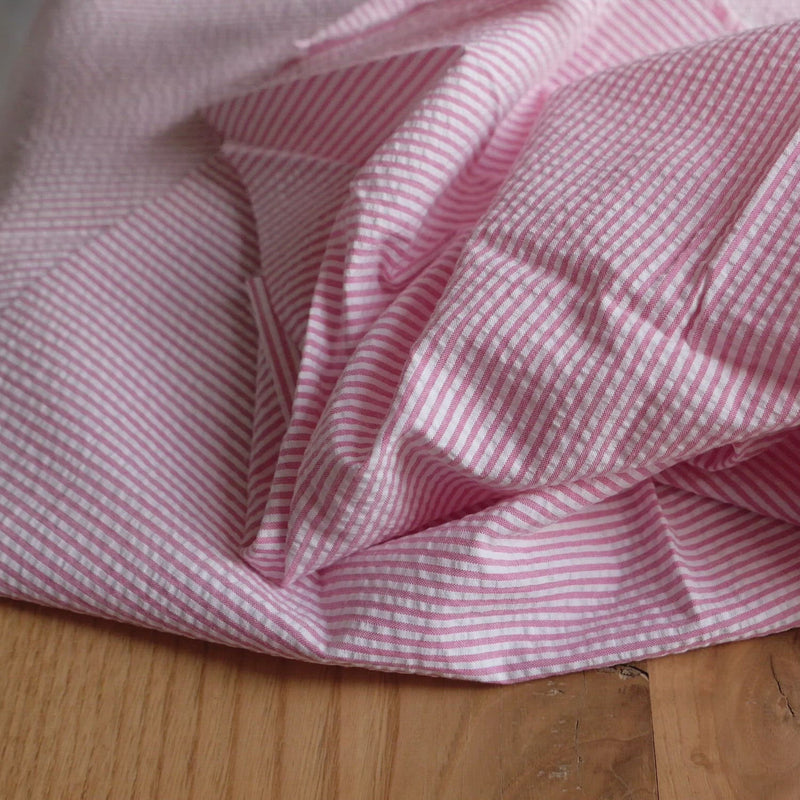 Pink and white striped seersucker fabric.