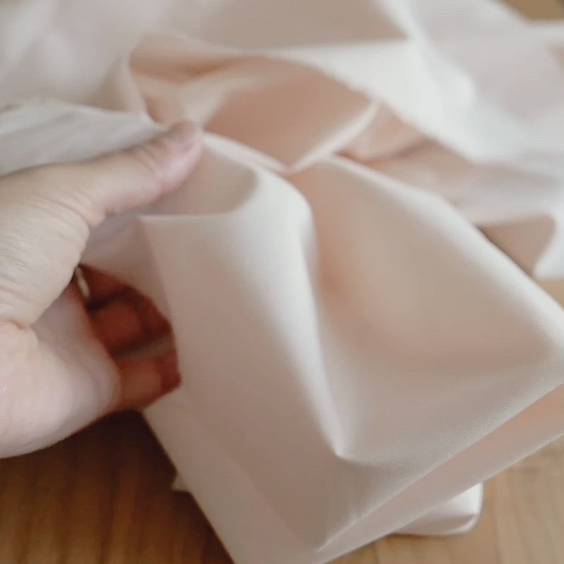 Plain, pale-peach fabric.