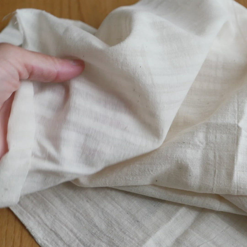 Cream fabric with a slubby texture and a self stripe.