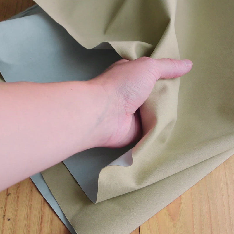 Hand crumples beige and blue bonded cotton.