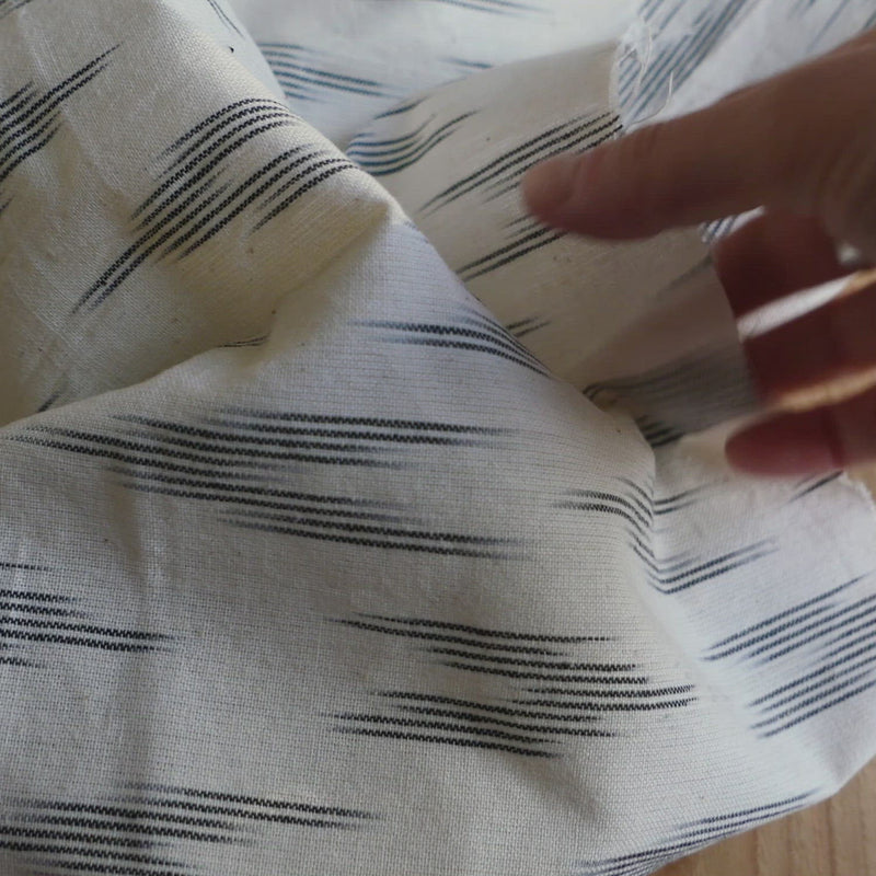 Cream fabric woven with a black geometric shape.