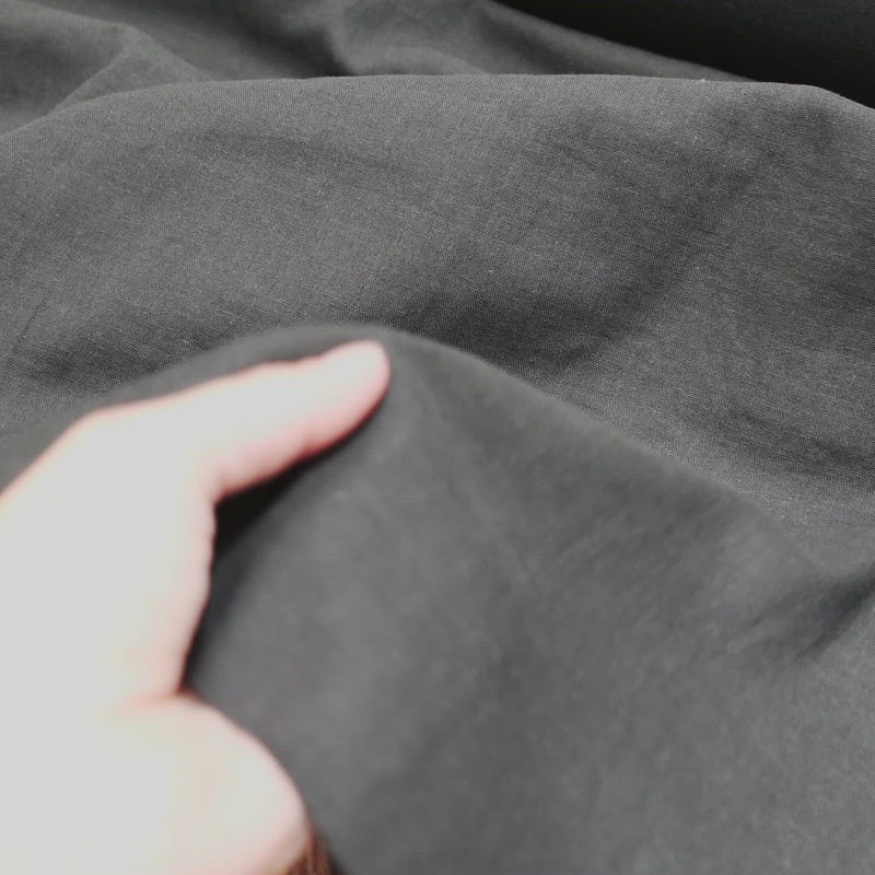 Black fabric with a soft crumpled texture. 