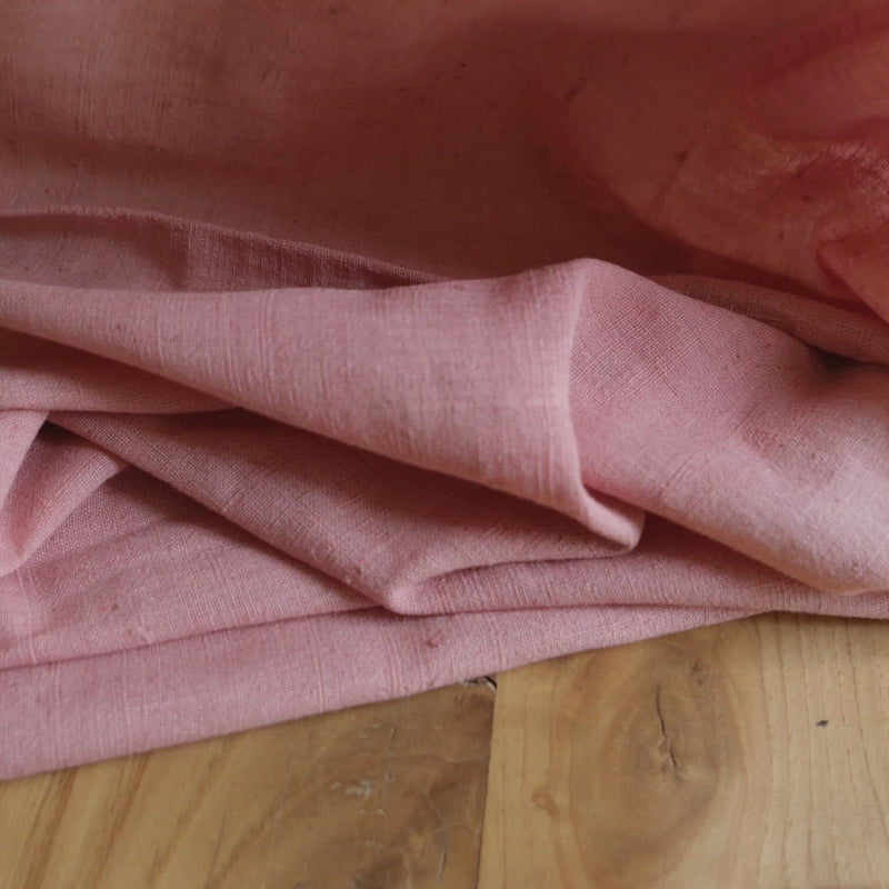 Pink fabric with a slubby texture.