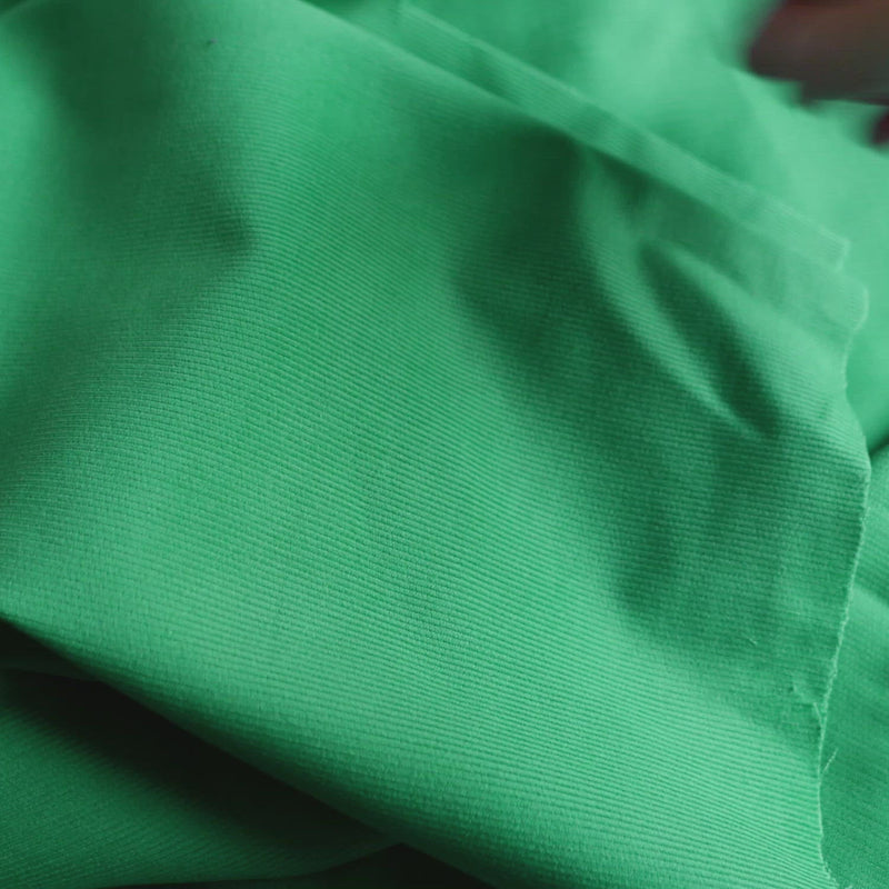 Green corduroy fabric with a very fine cord.