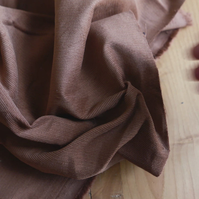 Brown corduroy fabric with a very fine cord.