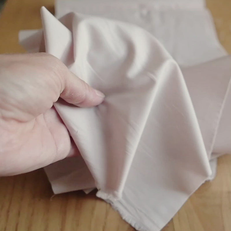 Plain, light-pink fabric. 