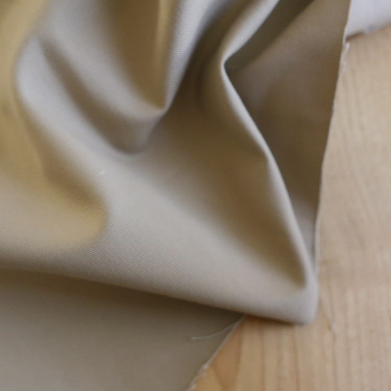 Plain beige fabric with a twill weave.