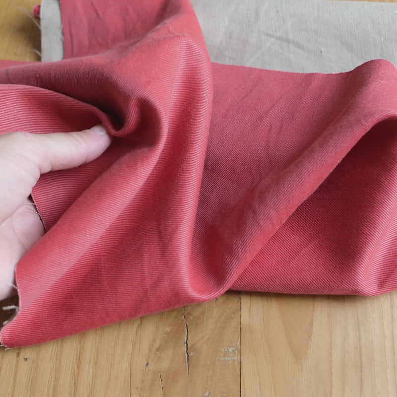 A beige twill fabric painted with a coral dye.