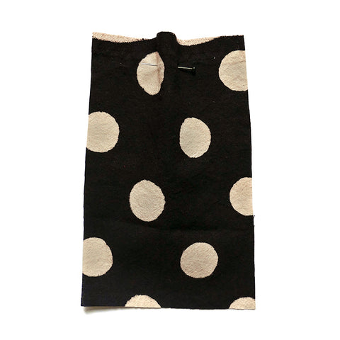Cream cotton fabric with a black polka dot print.