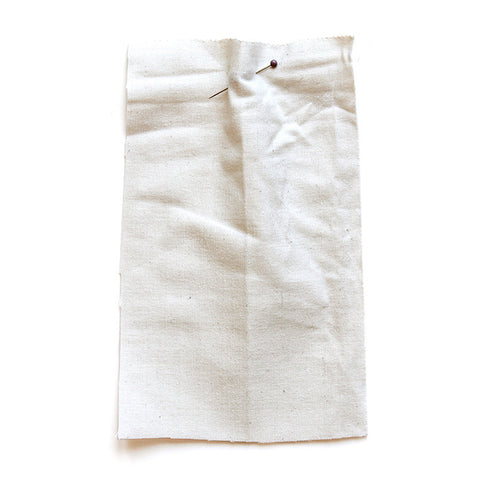 Plain white fabric which is creased. 