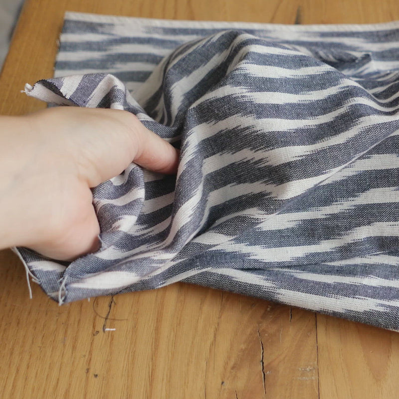 Blue and white fabric woven with a wave print. 