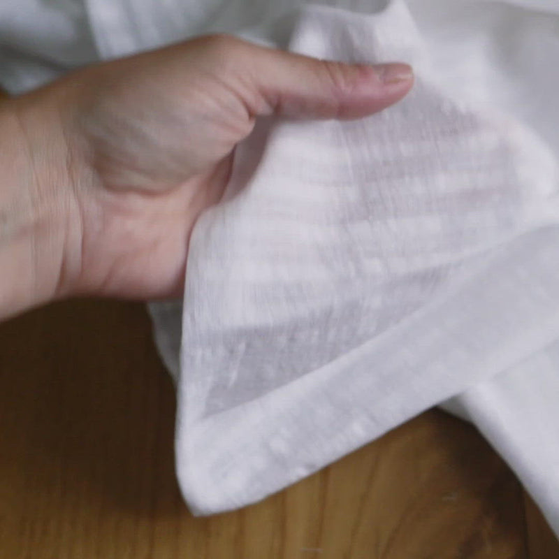 White fabric with a slubby texture and a self stripe.