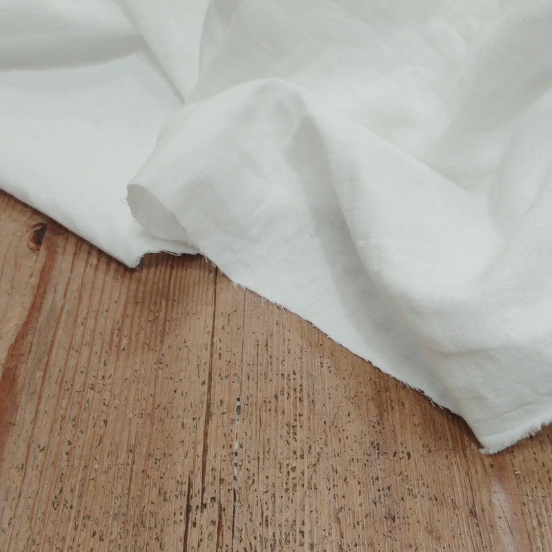 White fabric with a soft crumpled texture. 