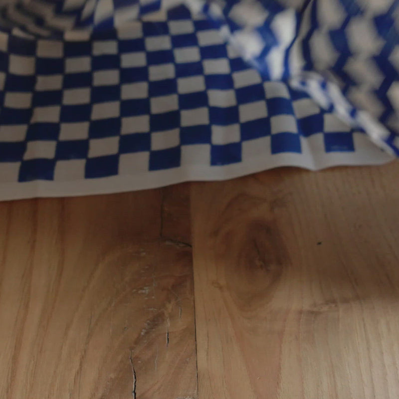 Hand crumples checked cotton.