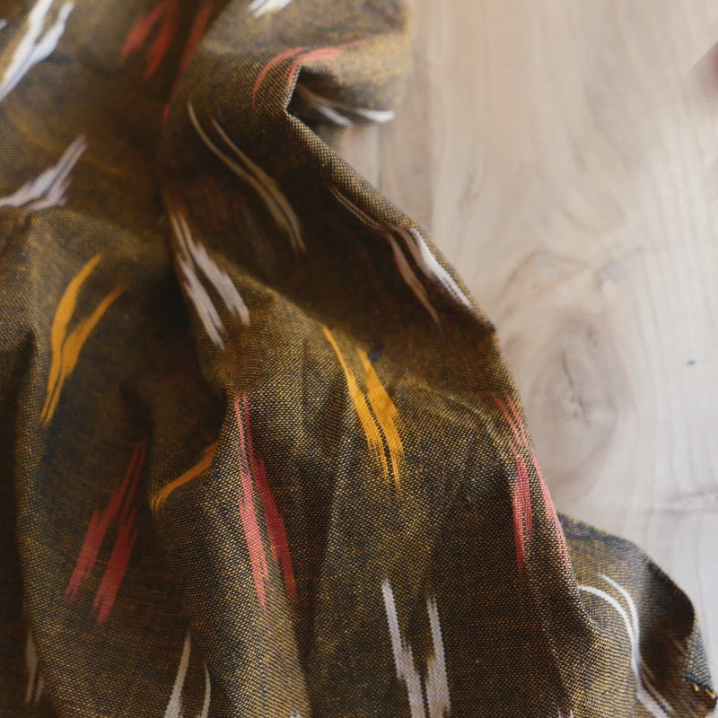 Brown fabric woven with a white, yellow and red arrow shape.