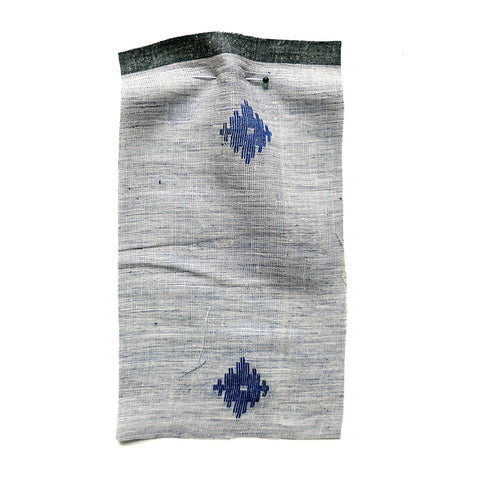 Blue chambray fabric with an embroidered blue emblem.