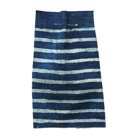 Indigo blue fabric printed with a white stripe. 