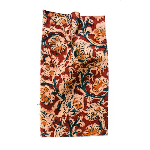 Printed floral fabric with a red ground and blue vine detail. 