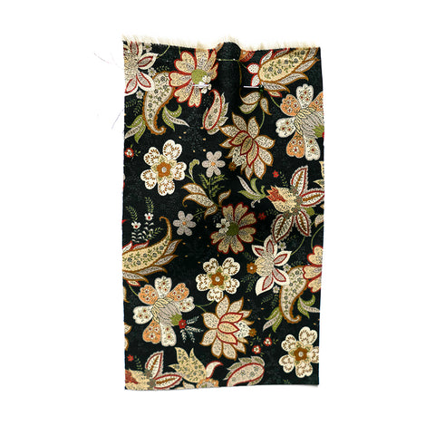 Black fabric printed with a floral & paisley pattern.