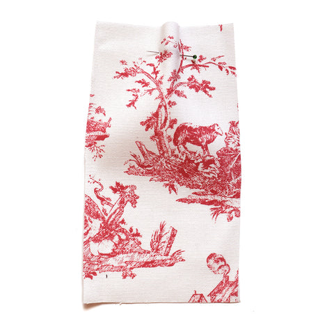 White cotton canvas printed with a red farm scene pattern. 