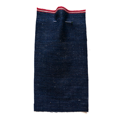 Mid blue denim fabric with a red selvedge.