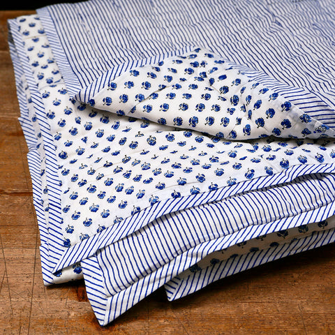 Folded blue and white quilt.