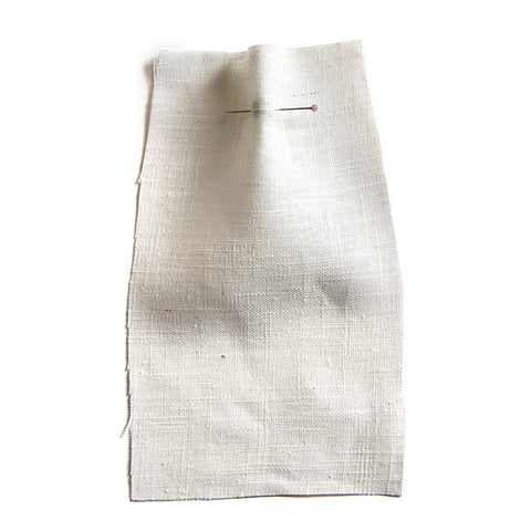 Ecru fabric with a slubby texture. 