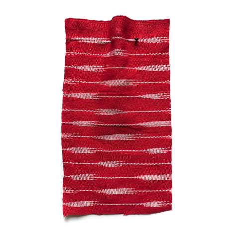 Red fabric with a white woven striped pattern. 