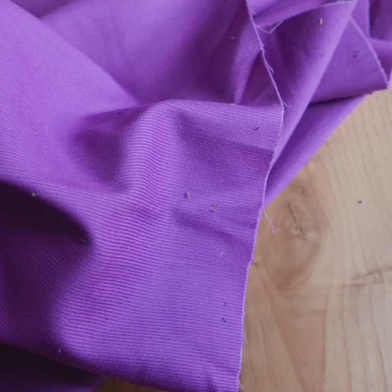 Purple corduroy fabric with a very fine cord.