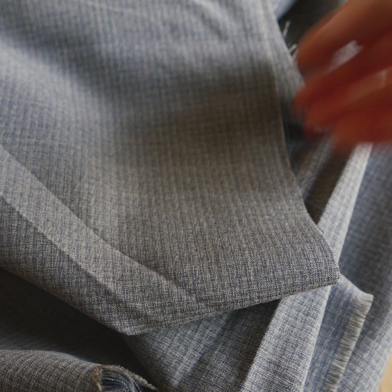 A video of grey wool fabric being drapey 