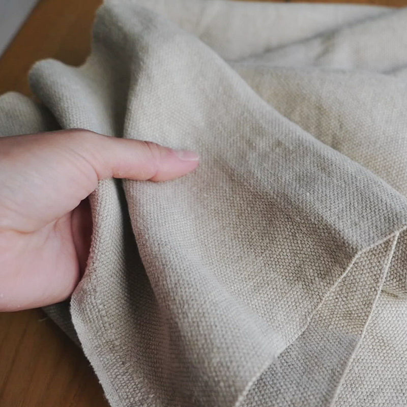 Beige fabric with a thick, canvas texture. 